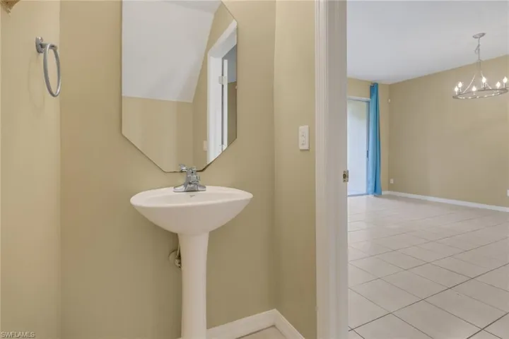 Bathroom with a chandelier and light tile patterned floors