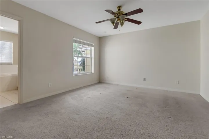 Unfurnished room featuring light colored carpet and a ceiling fan