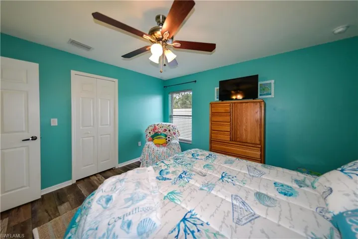 Bedroom featuring ceiling fan, a closet, and luxury vinyl wood style flooring