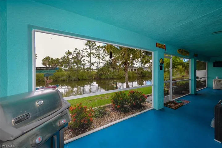 View of terrace featuring area for grilling and a water view