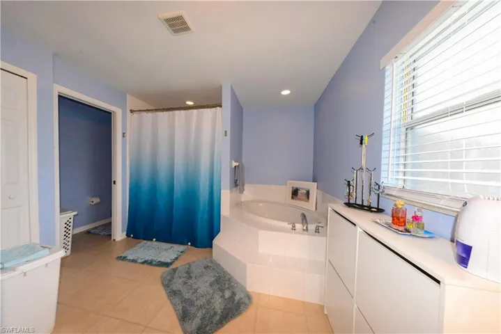 Bathroom featuring tile flooring and a relaxing tiled bath