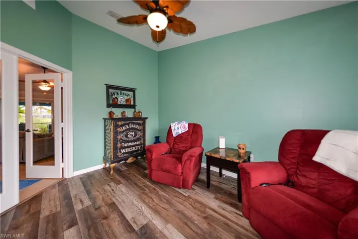 Office/Den front of house featuring ceiling fan, french doors, and luxury vinyl wood style flooring