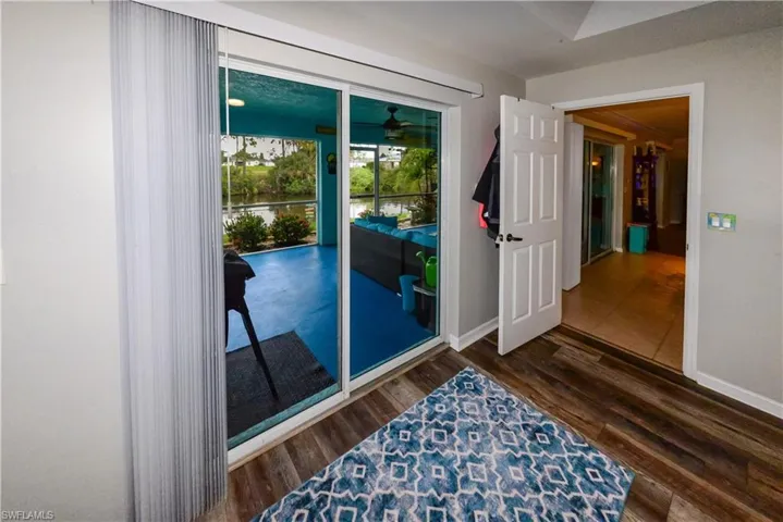 Primary Bedroom w/3 panel patio door and luxury vinyl wood-style flooring