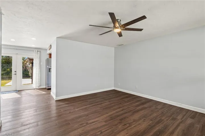 Spare room featuring ceiling fan, french doors, and dark wood-type flooring