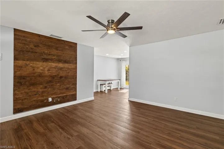 Spare room featuring dark hardwood / wood-style floors and ceiling fan