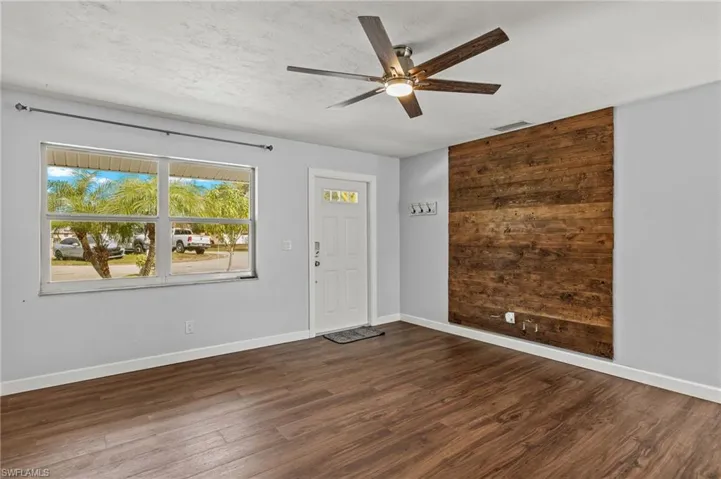 Entryway featuring ceiling fan and dark wood-type flooring