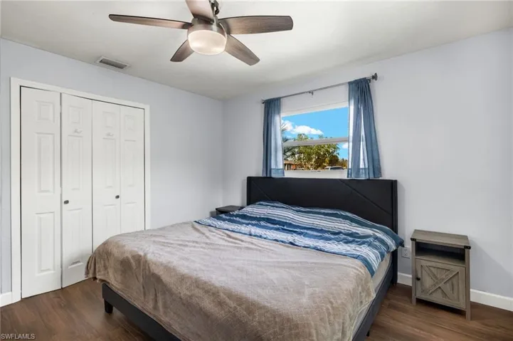 Bedroom featuring dark hardwood / wood-style flooring, ceiling fan, and a closet