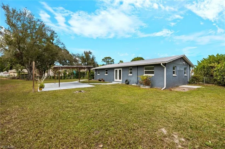 Rear view of house with a lawn and a patio area
