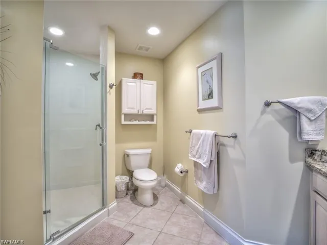 Bathroom with tile patterned flooring, vanity, toilet, and an enclosed shower
