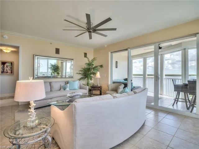 Living room featuring ceiling fan, a healthy amount of sunlight, light tile patterned flooring, and ornamental molding