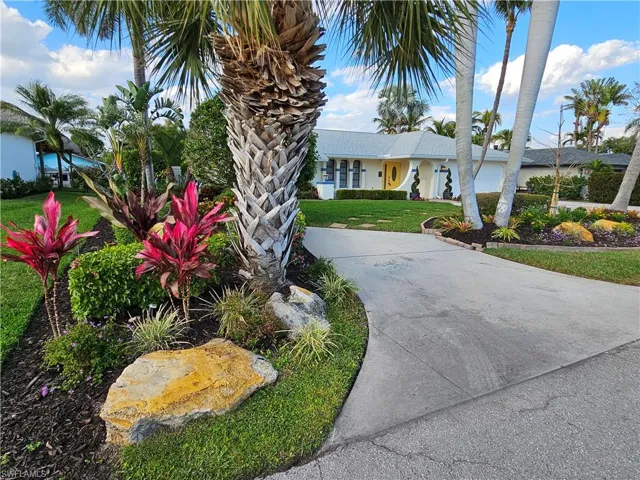View of front of property featuring concrete driveway and a front lawn