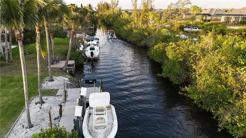 View of dock with a yard and a water view