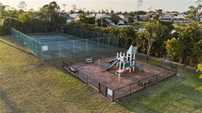 View of sport court featuring playground community, fence, and a residential view
