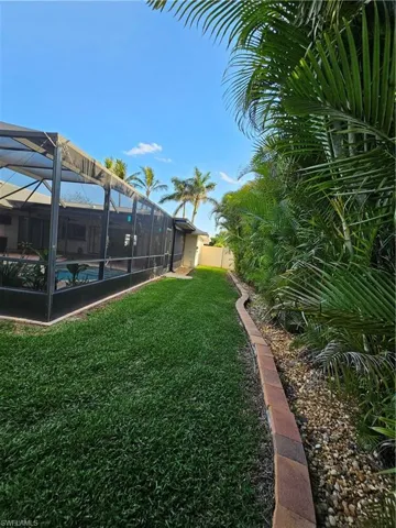 View of yard featuring a lanai, fence, and an outdoor pool
