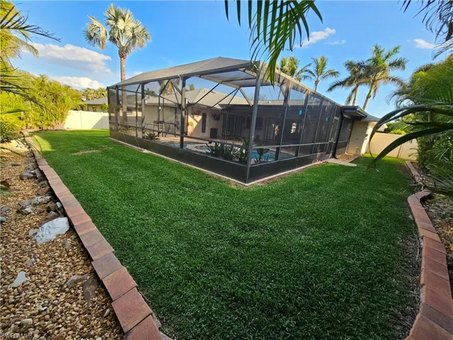 View of yard featuring a lanai, a fenced backyard, and an outdoor pool