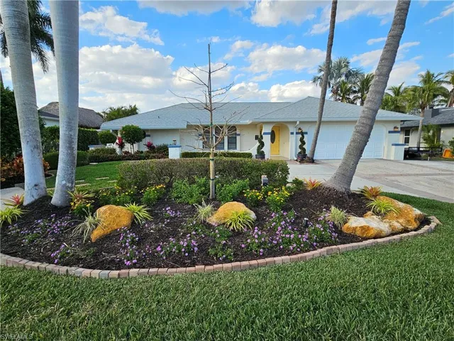 Single story home featuring an attached garage, concrete driveway, and a front yard