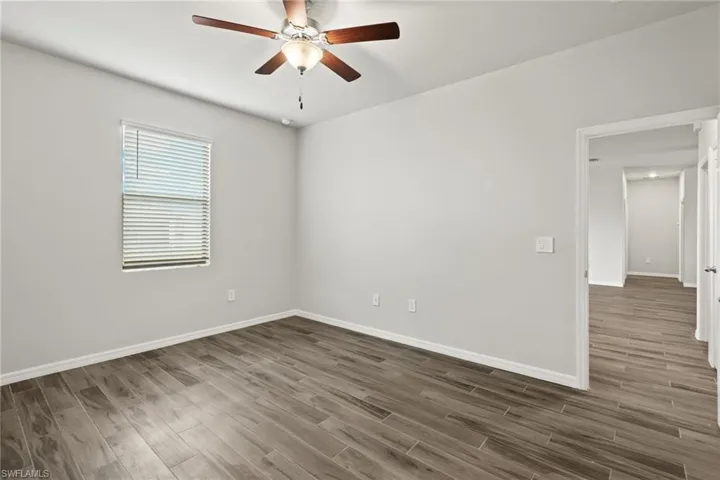 Spare room featuring ceiling fan and dark hardwood / wood-style floors
