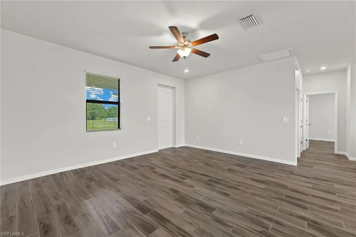 Spare room featuring dark hardwood / wood-style floors and ceiling fan