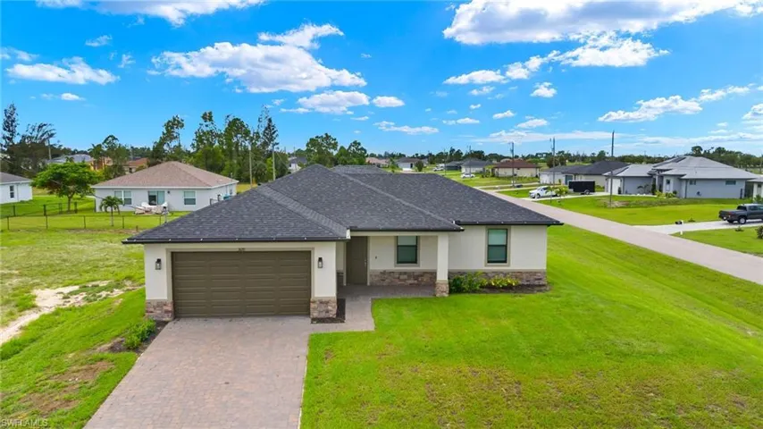 Ranch-style house with a garage and a front lawn