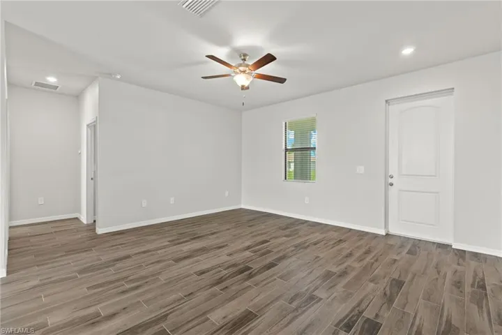 Unfurnished room with ceiling fan and dark wood-type flooring