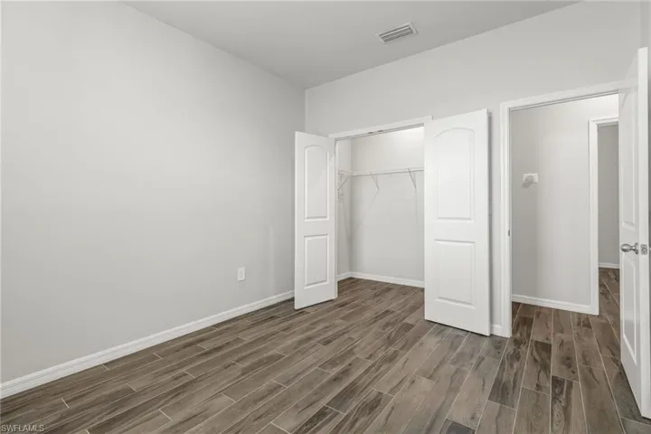 Unfurnished bedroom with dark wood-type flooring and a closet