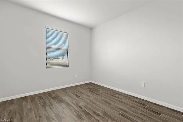 Empty room featuring dark hardwood / wood-style flooring