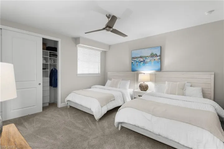 Carpeted bedroom featuring a closet and a ceiling fan