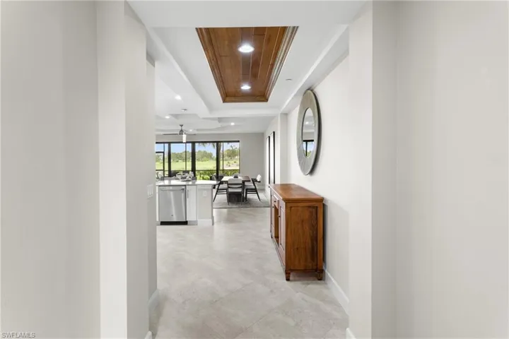 Hall featuring a raised ceiling and baseboards