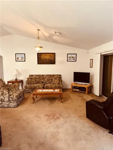Living room with vaulted ceiling and carpet flooring