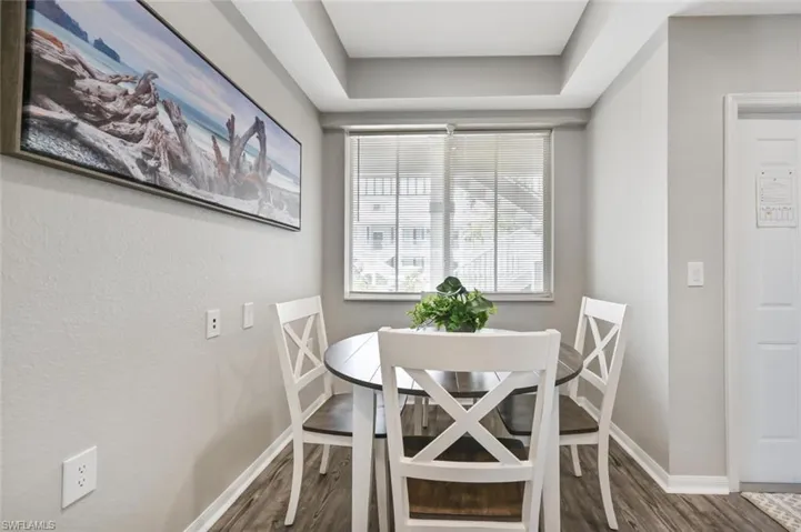 Dining room with hardwood / wood-style flooring and a raised ceiling