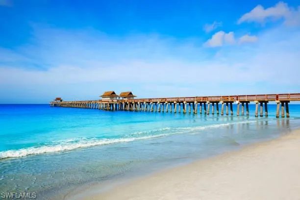 Dock area featuring a water view and a beach view