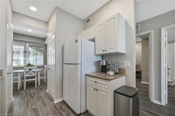 Kitchen with white cabinetry, dark wood-type flooring, and white refrigerator