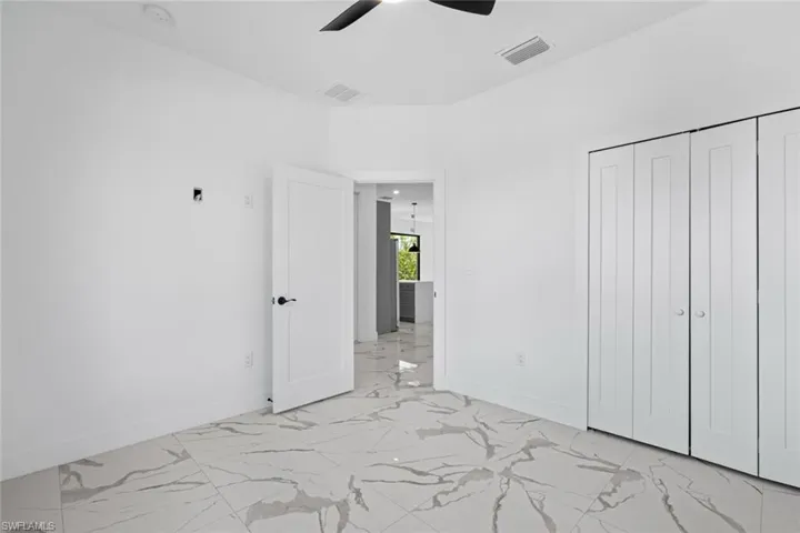 Unfurnished bedroom featuring visible vents, marble finish floor, and baseboards