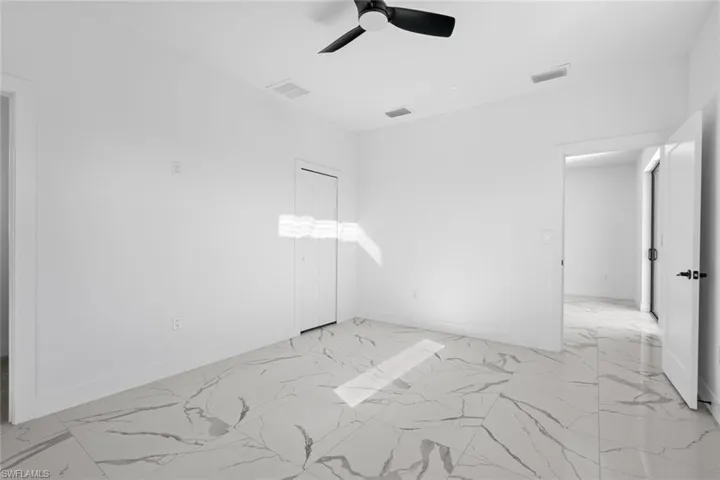 Spare room with baseboards, marble finish floor, and ceiling fan