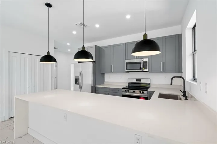 Kitchen featuring stainless steel appliances, visible vents, a sink, and recessed lighting