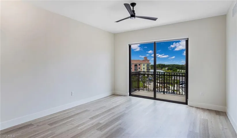 Empty room featuring light wood-style flooring, baseboards, a ceiling fan, and visible vents