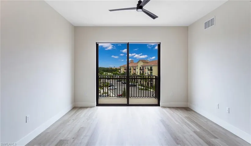 Empty room featuring visible vents, ceiling fan, wood finished floors, and baseboards