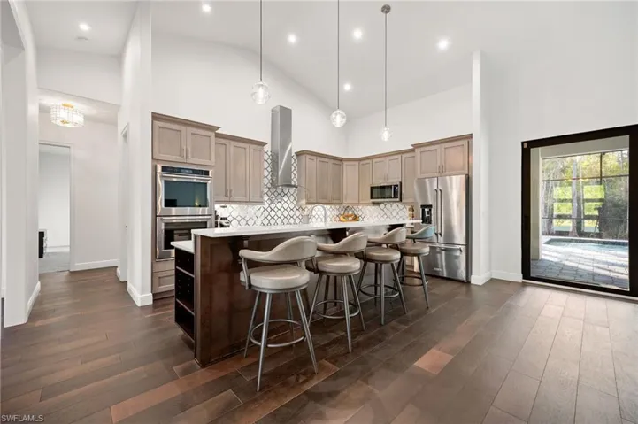 The chef’s kitchen features quartz countertops, dual-toned cabinetry, and high-end appliances, including double wall ovens & a built-in wine refrigerator.