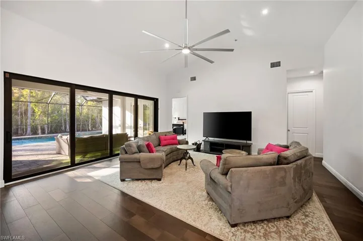 The light & bright interior showcases soaring ceilings, a neutral earthy palette, and warm espresso-toned hardwood flooring.