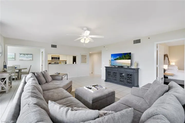 Living room with ceiling fan and light tile floors