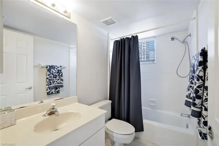 Full bathroom with oversized vanity, toilet, tile floors, and shower / tub combo