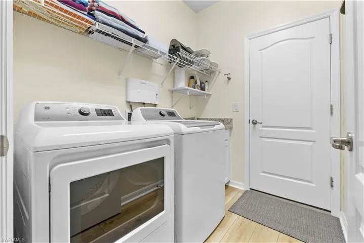 Laundry room featuring cabinet space, washing machine and dryer & sink. Clean Smart system