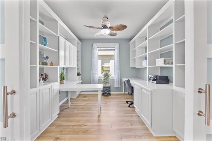 Office with 2 seating areas, cabinets and shelving