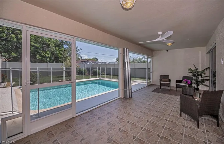 View of pool featuring a screened patio, an outdoor living space, and ceiling fan