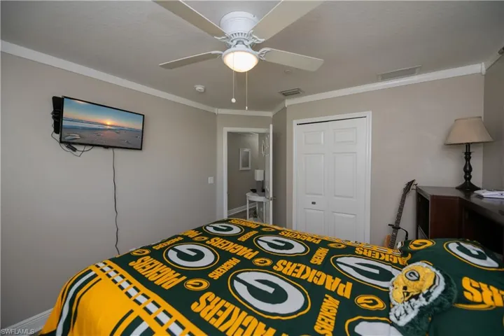 Bedroom featuring ceiling fan, a closet, and crown molding
