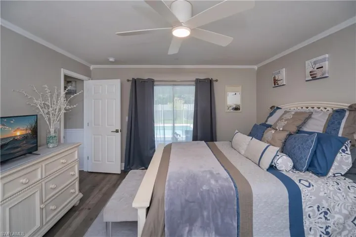 Bedroom featuring ornamental molding, LVT plank wood-style floors, sliding doors leads to the screened lani