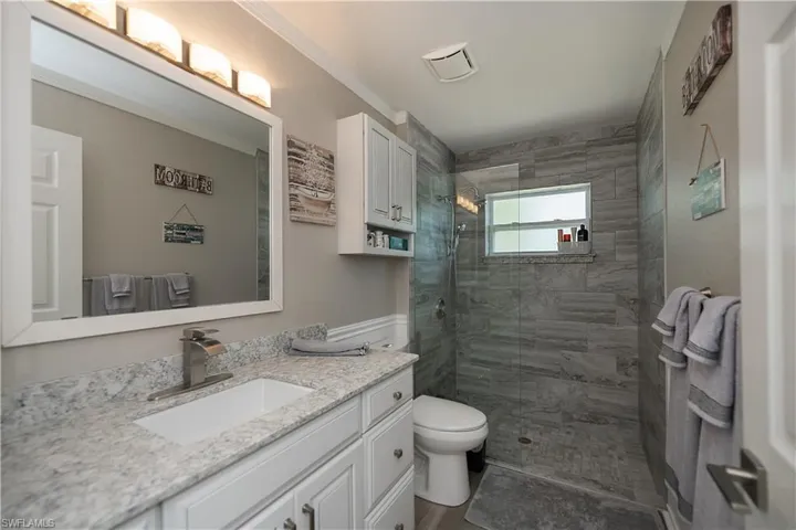 2nd bathroom with walk in shower, toilet, and vanity