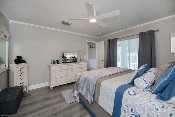 Bedroom featuring ceiling fan, and ornamental crown molding