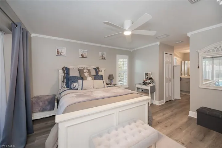Spacious master bedroom featuring connected bathroom, LVT plank wood-type flooring, sliding doors leads to the screened lani