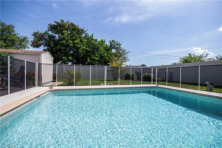 View of swimming pool with a safety fence